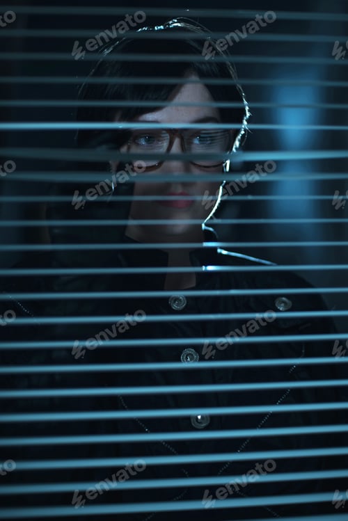 Preview: Eerie Retro 1980S Business Woman Looking Through Blinds In Office At Night.