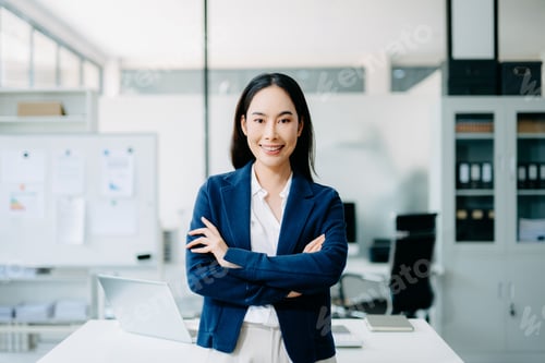 Vista previa: Confident Asian businesswoman standing in a modern office. Professional female leader