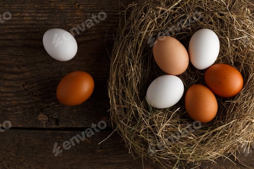 Preview: Chicken eggs in a nest on a wooden rustic background