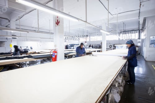 Preview: Male and female factory workers marking textile in clothing factory