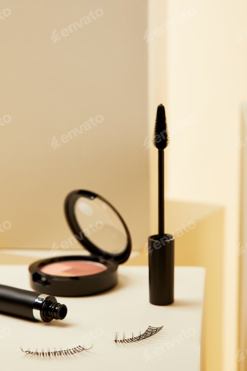 Preview: close-up shot of mascara with false eyelashes and shimmer on beige