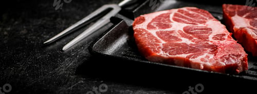 Preview: Raw pork steak on a grill pan.