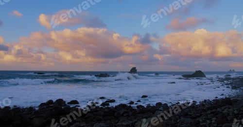 Preview: Big tide ocean waves with foam, splashes crushing beach with volcanic stones and rocks, beautiful