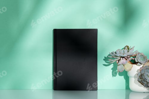 Preview: Black notebook and plant potted on mint background