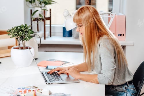 Preview: Concentrated on her job female office worker sits at table