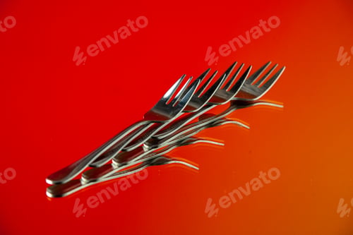 Preview: front view metal forks lined on orange background cutlery kitchen food color photo table dinner