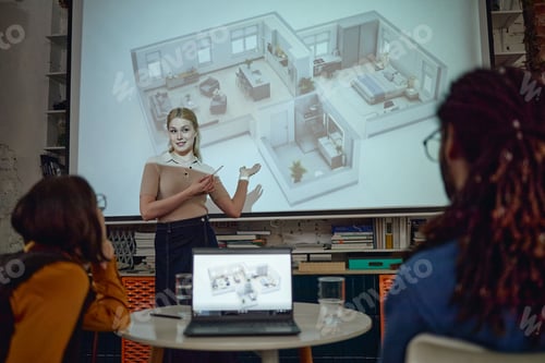 Preview: Caucasian Young Adult Woman Presenting Architectural Floor Plan to Diverse Team