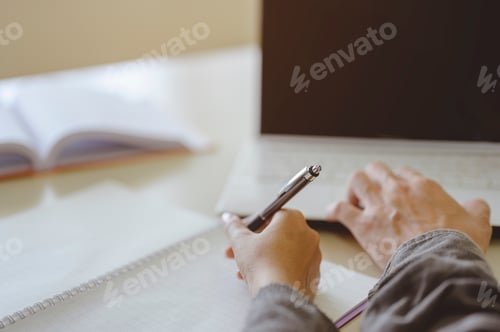 Preview: hands two students are reading and writing about presentation study for test preparation in library.