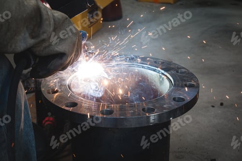 Preview: A welder is welding a flange assembly to a water pipe system.