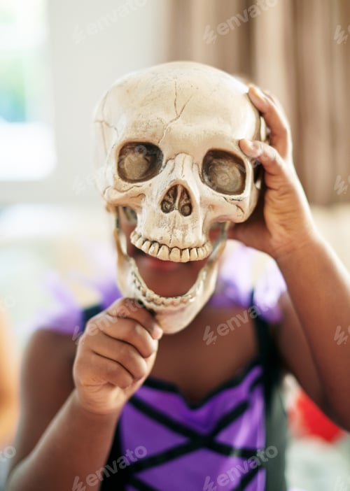 Preview: Do you think Im scary. Shot of an unrecognizable little child covering their face with a skull.