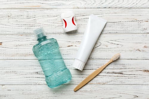 Preview: Mouthwash and other oral hygiene products on colored table top view
