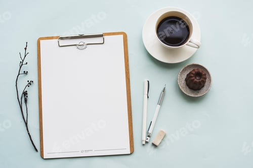 Preview: Aerial view of paper clipboard with coffee cup and cake