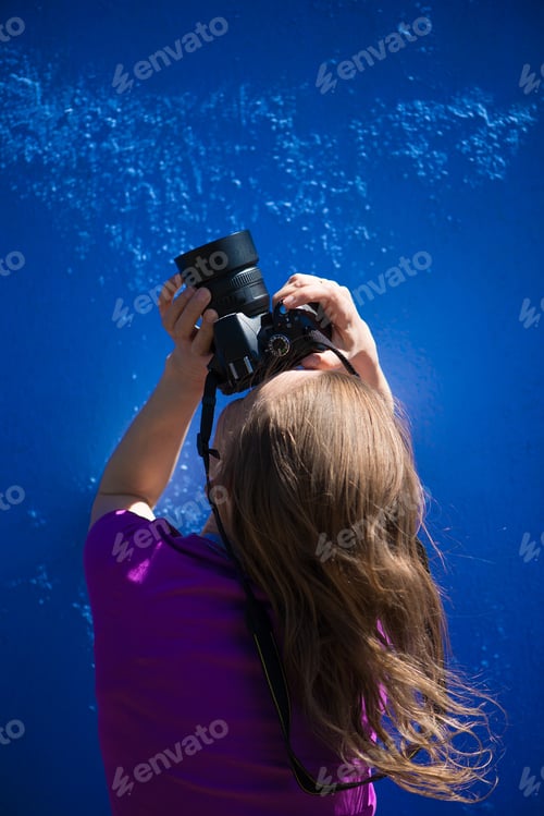 Preview: A portrait of a female photographer on a monochrome blue background