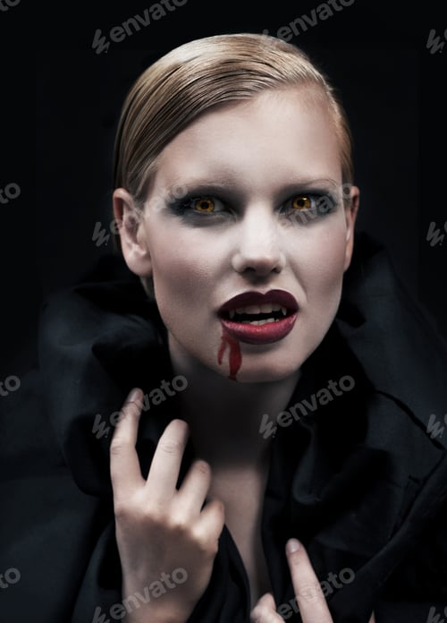 Preview: A provocative female vampire with blood running down her chin against a dark background