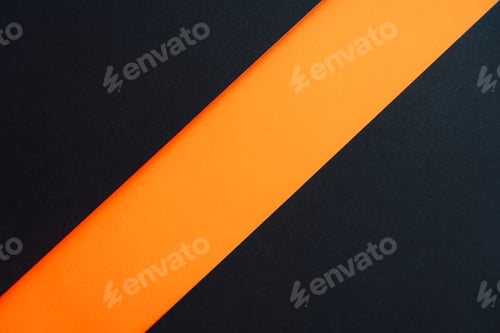 Preview: Orange stripe between two black surfaces, abstract paper background.