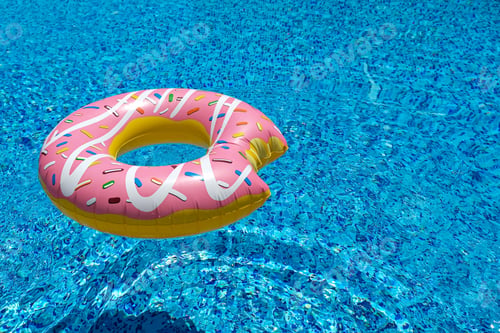 Preview: pink inflatable donut doughnut floating mattress in swimming pool. Beach pool accessories.