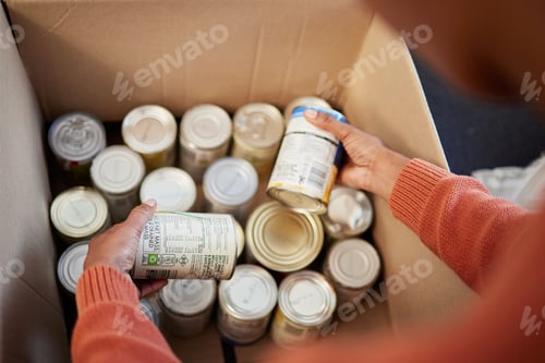 Preview: Donation, food in cans in box and hands of man checking stock, decision and volunteer with ngo help