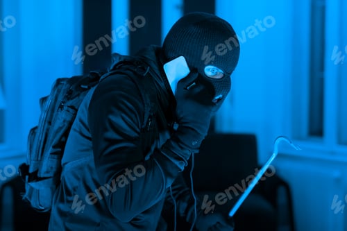 Preview: Burglar with phone and crowbar at night