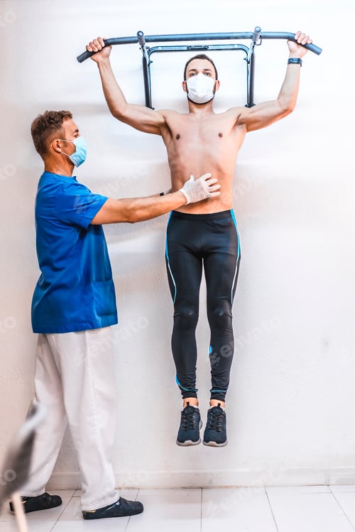 Preview: A shirtless patient with a physical therapist doing a crouched squat