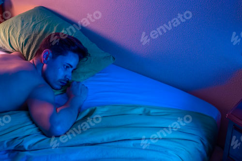 Preview: young man with insomnia trying to sleep at night