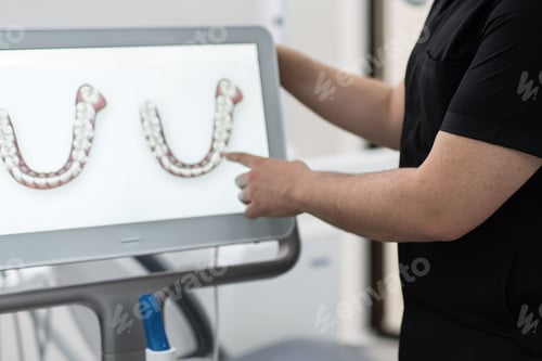 Preview: Dentist showing human jaws models on digital screen conducting presentation of innovative treatment