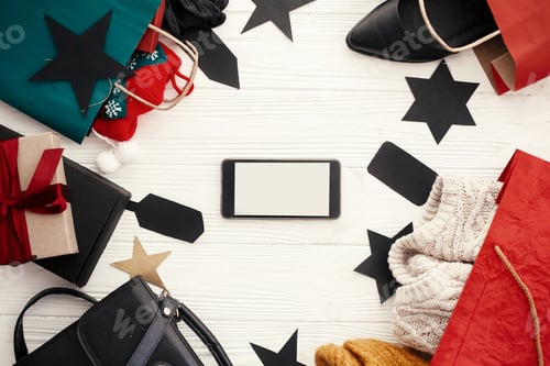 Preview: Phone with empty screen, bags, clothes and shoes, gift boxes