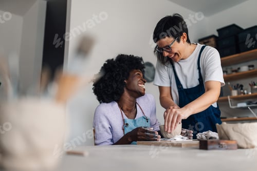 Preview: Happy interracial pottery class student and teacher making earthenware
