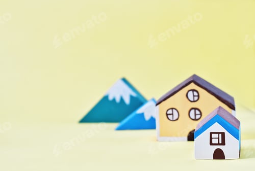 Preview: toy houses and mountains on yellow background. village suburban living. buying house in a country