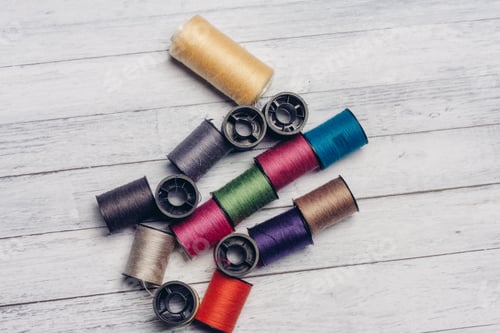 Preview: sewing accessories colored threads top view wooden background