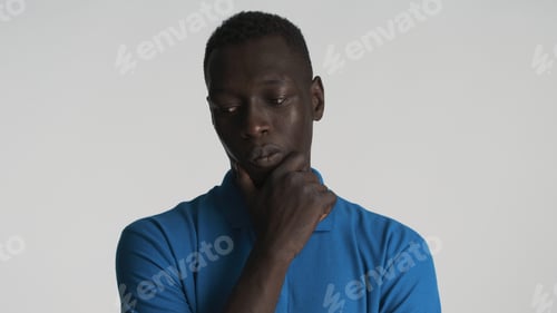 Preview: Young African American man rubbing chin thinking. Deep in thought expression