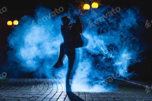 Preview: The man lifting a woman on the street with a blue smoke. night time