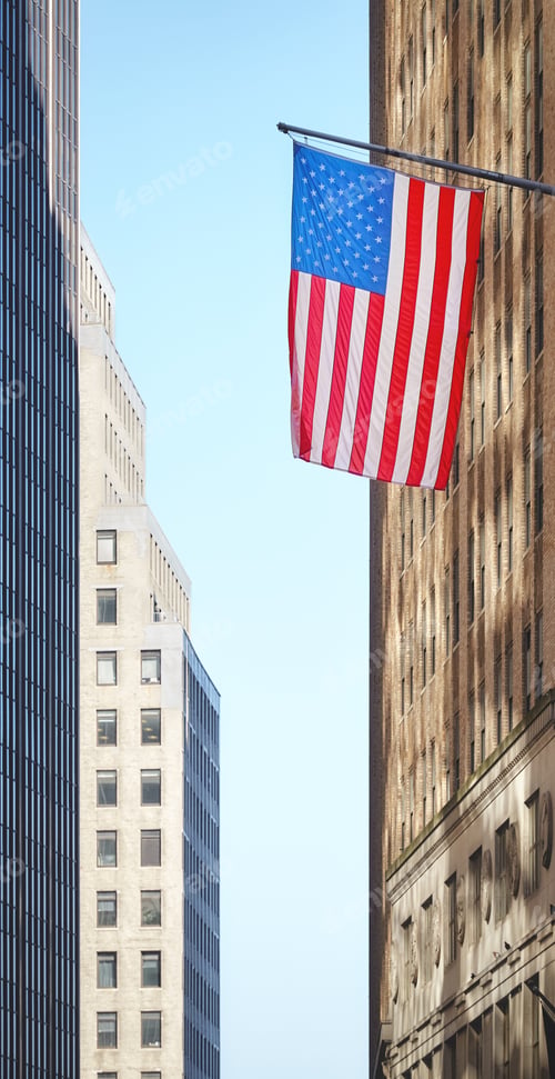 Preview: American flag with buildings in background, selective focus, New York City, USA.