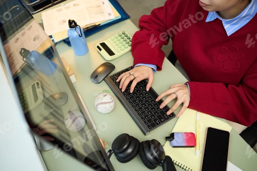 Preview: Young Woman Typing on Computer Keyboard While Working at Office Desk