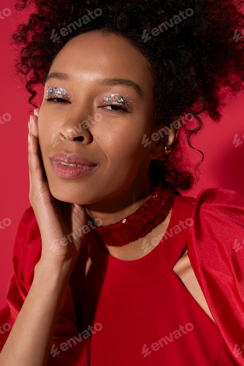 Preview: Captivating portrait of a young woman with sparkling makeup against a vibrant background