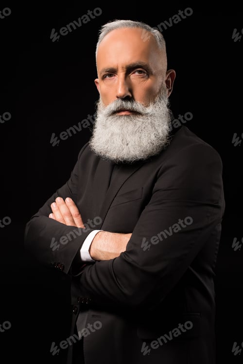 Preview: Half-length shot of businessman in a suit standing with his arms crossed