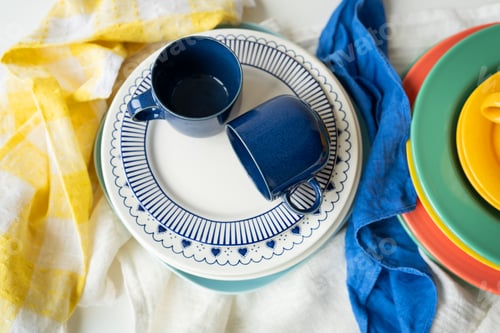 Preview: A pyramid of brightly colored bowls, plates and cups of different sizes and colors on the table.