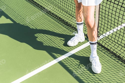 Preview: partial view of female tennis player standing near tennis net on court