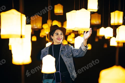 Preview: Closeup shot of a happy young lady in a room with many bright chandeliers