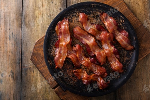 Preview: Cooked bacon on a wooden serving plate