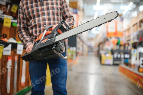 Preview: Worke holds electric saw in tool store