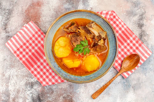 Preview: top view bozbash soup kitchen towel a wooden spoon on nude background azerbaijani cuisine
