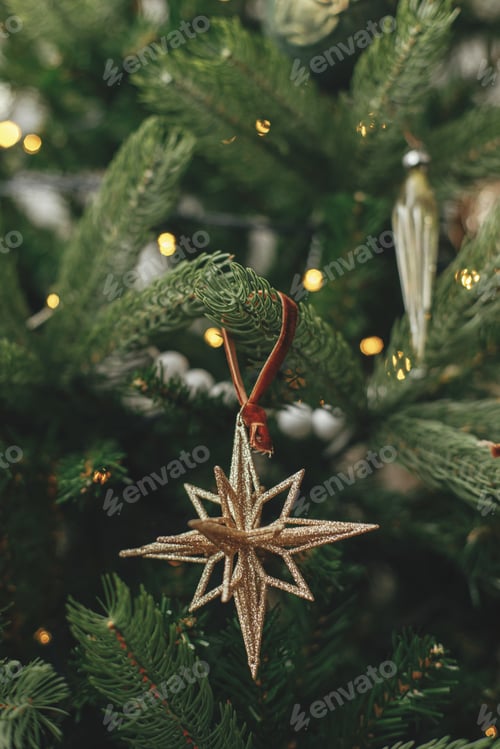 Preview: Christmas tree with vintage star and golden lights close up in festive room. Winter holidays