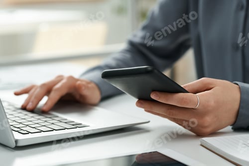 Preview: Woman connecting smartphone with laptop