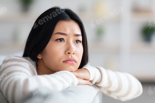 Preview: Depression Concept. Closeup Of Upset Asian Female Sitting On Couch At Home