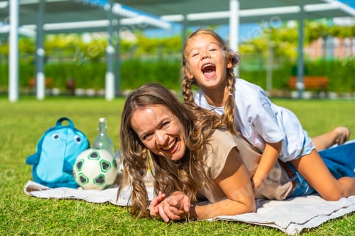 Preview: Mother and daughter laughing enjoying summer day in park