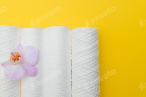 Preview: Water filters. Carbon cartridges and a glass on a yellow background. Household filtration system