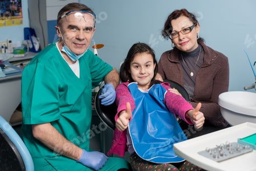 Preview: Girl with on the first dental visit. Senior pediatric dentist with mother treating patient teeth