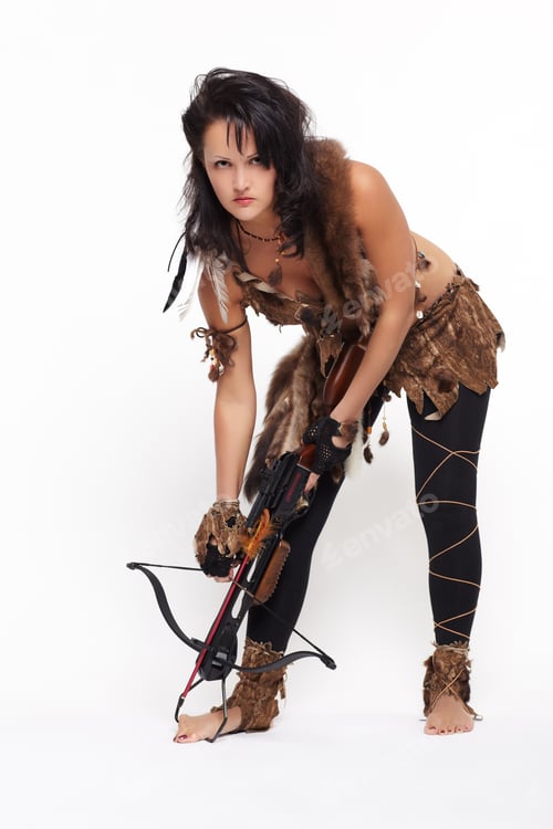 Preview: Full-Length Portrait Of Beautiful Woman Fur Hunter Reloading Crossbow On Gray