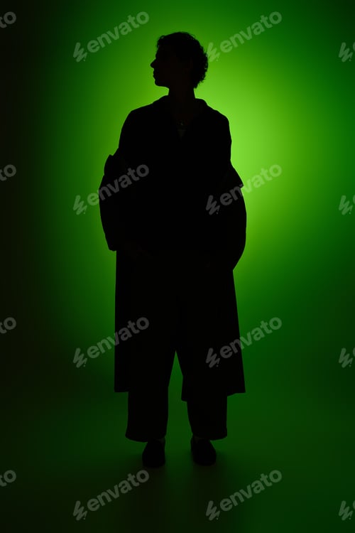 Preview: Elegant young man stands confidently against a vibrant green background showcasing modern style