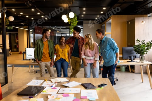 Preview: Portrait of diverse colleagues in discussion standing in casual office meeting